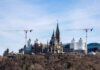 A view of construction cranes around the iconic Ottawa Parliament building under renovation.