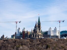 A view of construction cranes around the iconic Ottawa Parliament building under renovation.