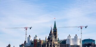 A view of construction cranes around the iconic Ottawa Parliament building under renovation.