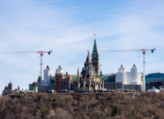 A view of construction cranes around the iconic Ottawa Parliament building under renovation.