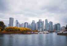 Captivating view of Vancouver skyline during autumn, showcasing skyscrapers and waterfront reflections.