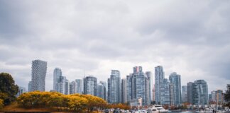 Captivating view of Vancouver skyline during autumn, showcasing skyscrapers and waterfront reflections.