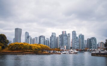 Captivating view of Vancouver skyline during autumn, showcasing skyscrapers and waterfront reflections.