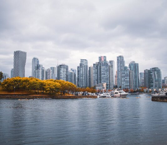 Captivating view of Vancouver skyline during autumn, showcasing skyscrapers and waterfront reflections.