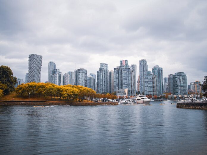 Captivating view of Vancouver skyline during autumn, showcasing skyscrapers and waterfront reflections.