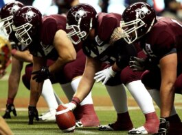 Dynamic shot of American football players in formation on the field, ready to start the game.