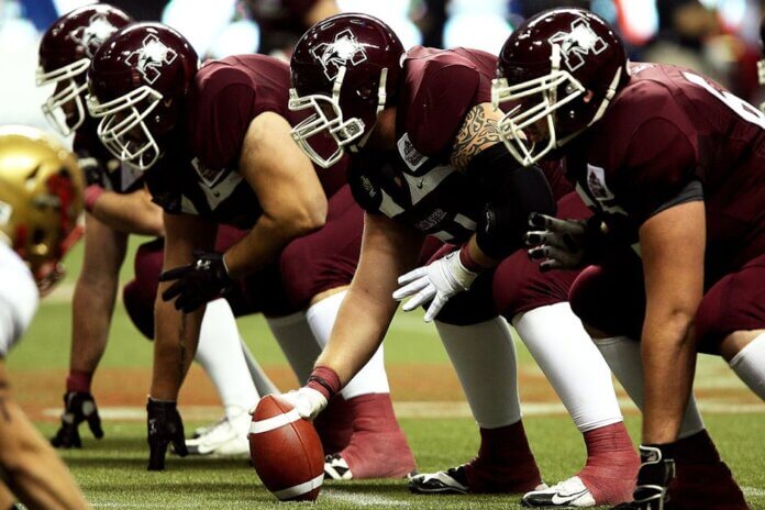 Dynamic shot of American football players in formation on the field, ready to start the game.