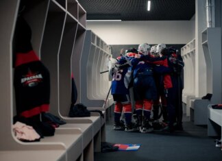Как устроена лотерея драфта НХЛ и что важно для «Кэнакс» A hockey team in a locker room huddles for motivation, symbolizing teamwork and sportsmanship.