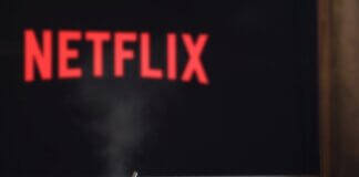 A steaming mug on a table in front of a TV displaying Netflix, creating a cozy indoor atmosphere.