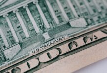 From above ten dollar banknote with inscription and United States treasury building placed on table
