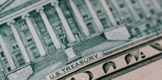 From above ten dollar banknote with inscription and United States treasury building placed on table