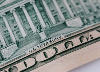 Полиевр: либералы добавят триллион долларов к госдолгу к 2031 году From above ten dollar banknote with inscription and United States treasury building placed on table