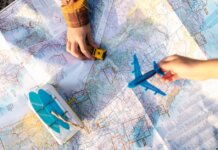 Hands holding a toy airplane and car over a map, symbolizing travel planning and exploration.