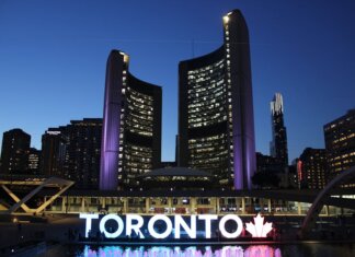 Канада на форуме ООН обсудила с мировыми партнёрами миграционные приоритеты Toronto City Hall stands illuminated against the night sky, showcasing vibrant city lights and iconic architecture.