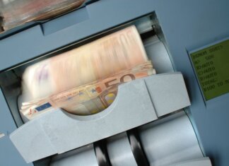 50 Euro banknotes being processed in a high-speed counting machine, showcasing technology and finance in action.