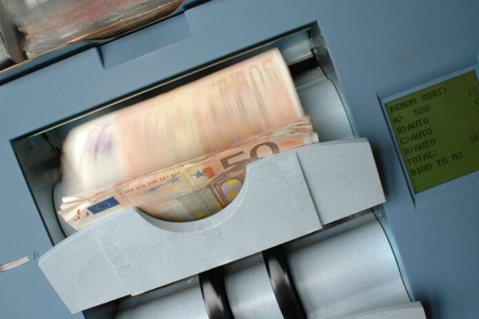 50 Euro banknotes being processed in a high-speed counting machine, showcasing technology and finance in action. 50 Euro banknotes being processed in a high-speed counting machine, showcasing technology and finance in action.