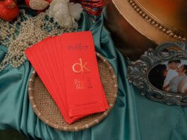 A beautifully arranged wedding invitation with pearls and a romantic photo.