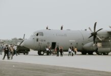 В Эдмонтоне открыли первые квартиры с нулевым выбросом для военных A Canadian military transport aircraft on a runway with people boarding.
