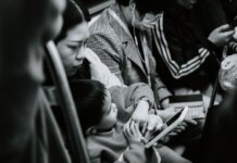 A candid black and white photo capturing a family scene in a Nanjing subway.