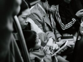 A candid black and white photo capturing a family scene in a Nanjing subway.
