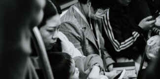 A candid black and white photo capturing a family scene in a Nanjing subway.