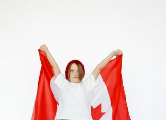 A child joyfully holding a Canadian flag, celebrating patriotism and freedom.