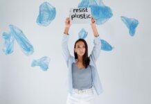 A determined woman holds a sign against plastic pollution amidst floating bags.