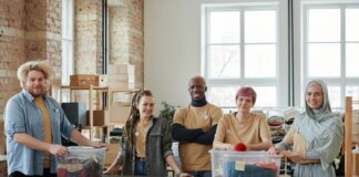 A diverse team of volunteers sorts clothing donations in an organized workspace, promoting community support.
