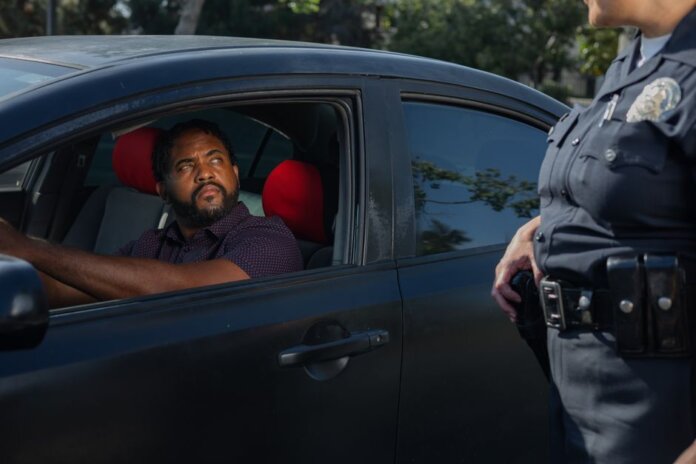 A driver receives a traffic ticket from a police officer for a speeding violation. A driver receives a traffic ticket from a police officer for a speeding violation.