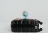 A globe placed on a black suitcase symbolizing global travel and adventure.