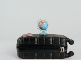 A globe placed on a black suitcase symbolizing global travel and adventure.