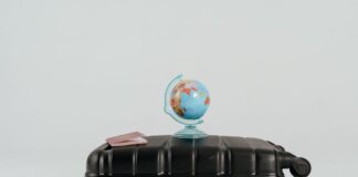 A globe placed on a black suitcase symbolizing global travel and adventure.