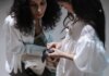 A mother and daughter interact with a smartwatch, showcasing family bonding with modern tech.