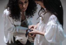 Meta будет предупреждать родителей о суицидальных настроениях подростков A mother and daughter interact with a smartwatch, showcasing family bonding with modern tech.