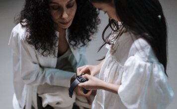 Meta будет предупреждать родителей о суицидальных настроениях подростков A mother and daughter interact with a smartwatch, showcasing family bonding with modern tech.