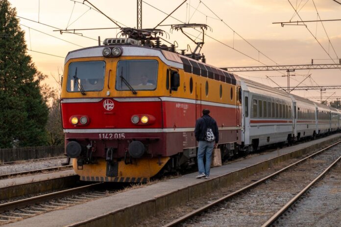 A passenger boards a vintage train at sunset in Kutina, Croatia. Scenic travel moment. A passenger boards a vintage train at sunset in Kutina, Croatia. Scenic travel moment.
