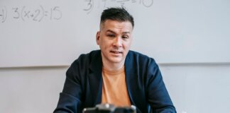 A professional educator conducting an online class, engaging with students via video call.