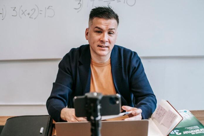 A professional educator conducting an online class, engaging with students via video call. A professional educator conducting an online class, engaging with students via video call.