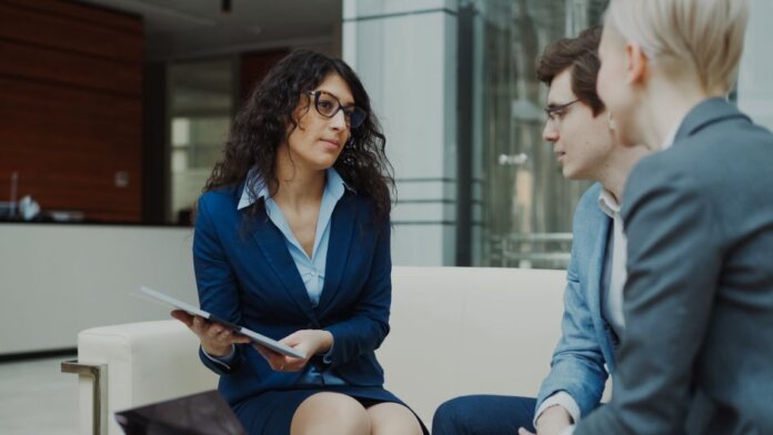 A professional meeting with a team discussing business strategies in a modern office setting. A professional meeting with a team discussing business strategies in a modern office setting.