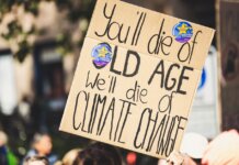 A protest sign highlighting climate change issues during a daylight rally.