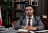 Канада назначила нового посла в Королевстве Бахрейн A serious businessman in a suit writing at his desk in a formal office setting.