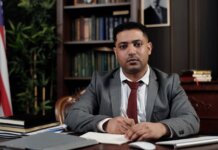 Канада назначила нового посла в Королевстве Бахрейн A serious businessman in a suit writing at his desk in a formal office setting.