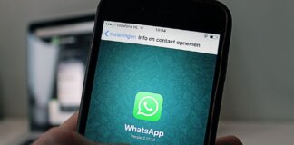 A smartphone displaying the WhatsApp application screen held by a person.