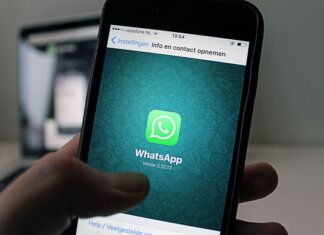 A smartphone displaying the WhatsApp application screen held by a person.