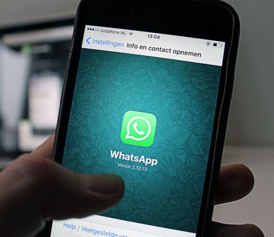 A smartphone displaying the WhatsApp application screen held by a person.