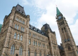 Пьер Пуалиевр выступил с заявлением в связи с Тиша бе-Ав A view of the historical Parliament Hill building in Ottawa against a clear sky.