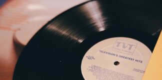 A vintage vinyl record titled 'Television's Greatest Hits' on a turntable.