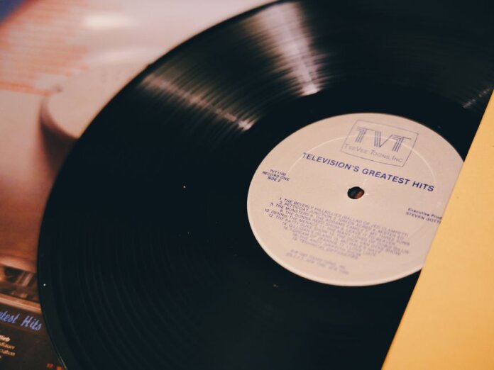 A vintage vinyl record titled 'Television's Greatest Hits' on a turntable. A vintage vinyl record titled 'Television's Greatest Hits' on a turntable.