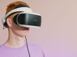 A young caucasian man wearing VR glasses, experiencing virtual reality.