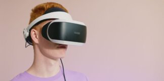 A young caucasian man wearing VR glasses, experiencing virtual reality.